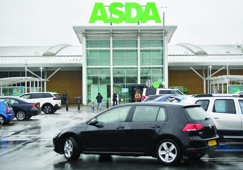 Customers arrive and leave from an Asda supremarket store in Ashford, south east England on October 2, 2020. - US retail giant Walmart has agreed Thursday to sell its British supermarket chain Asda to two UK firms for £6.8 billion ($8.7 billion, 7.4 billion euros). (Photo by Ben STANSALL / AFP)