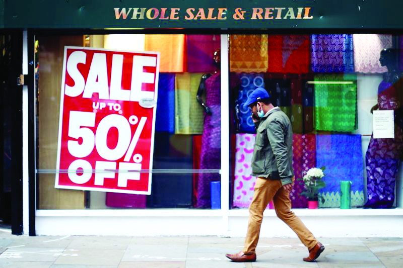 FILE PHOTO: A man walks past the shop with a sale sign in the window, amid the outbreak of the coronavirus disease (COVID-19), in London, Britain, September 28, 2020. REUTERS/Hannah McKay/File Photo