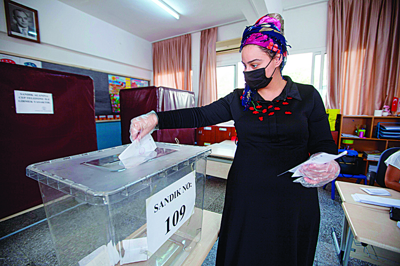 A Turkish-Cypriot woman casts her ballot at a voting station in the northern part of Nicosia, the capital of the self-proclaimed Turkish Republic of Northern Cyprus (TRNC), during the presidential elections on October 10, 2020. - The TRNC started a vote today for a new leader amid heightened tensions on the divided island and in the wider eastern Mediterranean region.nThe election in the breakaway republic that is recognised only by Ankara comes three days after Turkish troops controversially reopened access to the seaside ghost town of Varosha for the first time in decades. (Photo by Birol BEBEK / AFP)
