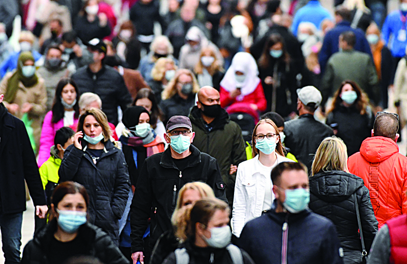 People wearing protective face masks walk in the pedestrian area in the city of Dortmund, western Germany, on October 14, 2020, amid the ongoing novel coronavirus (Covid-19) pandemic. - In Dortmund, wearing a mask is mandatory in the pedestrian zone since October 13 as a measure to curb the spread of the coronavirus. The German Chancellor wants measures toughened up to fight a surge in coronavirus infections, including requiring masks in more places and limiting numbers of people gathering for private events, according to a draft policy paper seen by AFP. The proposals to be discussed with premiers from Germany's 16 states later on October 14 would see the restrictions kick in once an area records 35 new infections per 100,000 people over seven days. (Photo by Ina FASSBENDER / AFP)