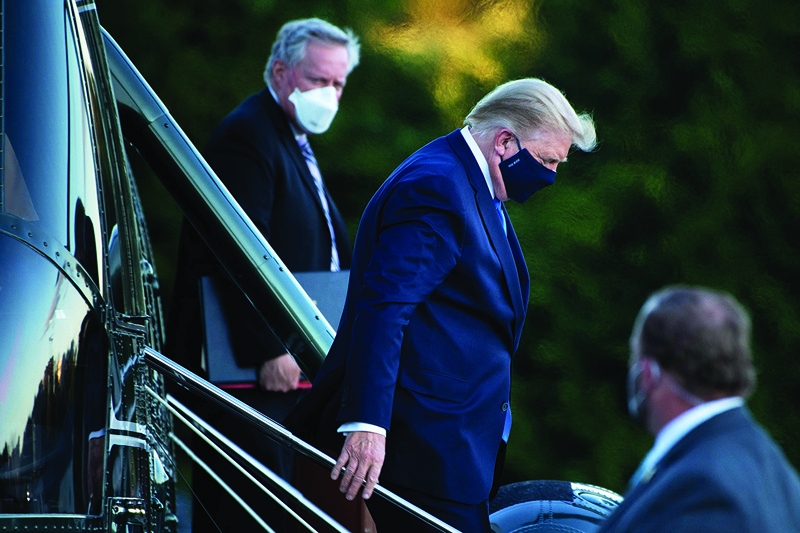 TOPSHOT - White House Chief of Staff Mark Meadows (L) watches as US President Donald Trump (C) walks off Marine One while arriving at Walter Reed Medical Center in Bethesda, Maryland on October 2, 2020. - President Donald Trump will spend the coming days in a military hospital just outside Washington to undergo treatment for the coronavirus, but will continue to work, the White House said Friday (Photo by Brendan Smialowski / AFP)