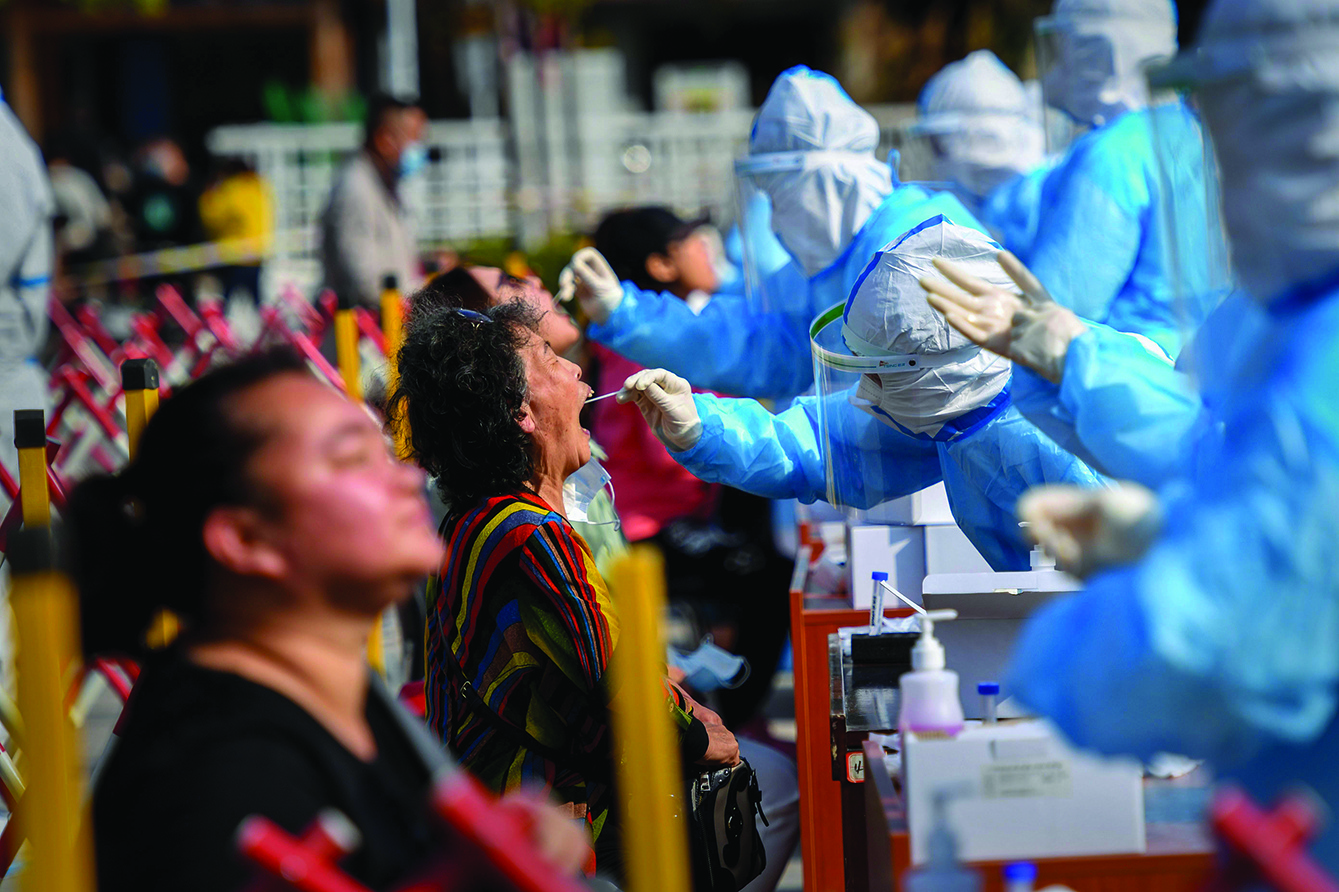 TOPSHOT - A health worker takes a swab from a resident to be tested for the COVID-19 coronavirus in Qingdao, in China's eastern Shandong province on October 12, 2020. (Photo by STR / AFP) / China OUT