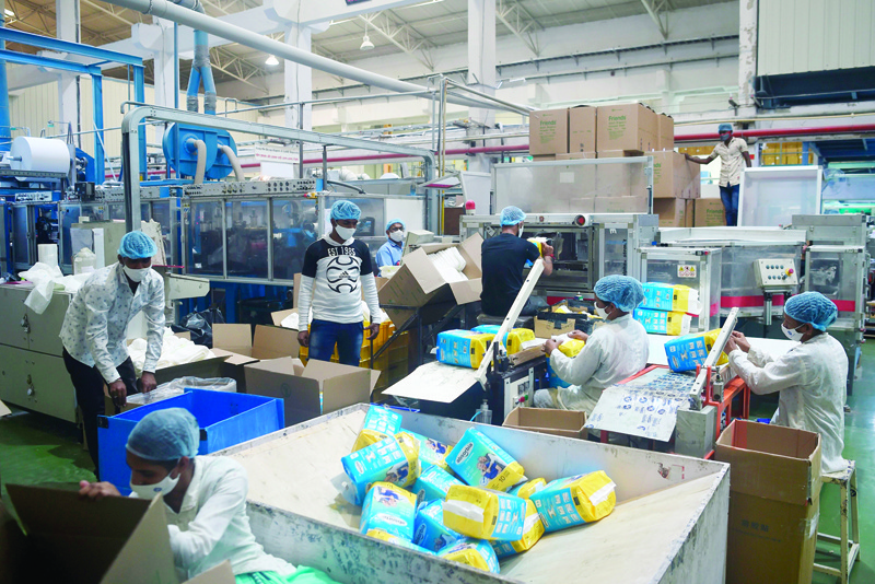 In this picture taken on October 1, 2020, staff members work on the production line of a diaper manufacturing plant in Sinnar, in the Indian state of Maharashtra. - India is on course to top the world in coronavirus cases, but from Maharashtra's whirring factories to Kolkata's thronging markets, people are back at work -- and eager to forget the pandemic for festival season. (Photo by Punit PARANJPE / AFP) / TO GO WITH Health-virus-India-economy, FOCUS by Ammu Kannampilly and Satyajit Shaw