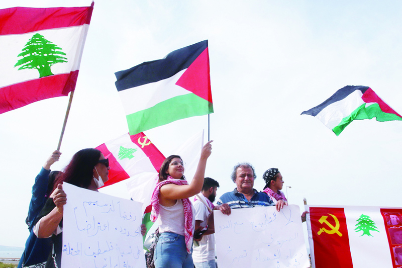 Supporters of the Lebanese Communist Party take part in a demonstration denouncing the talks between Lebanese and Israeli delegations on the demarcation of the maritime frontier between the two countries, which are still in a state of war, in the southern Lebanese border town of Naqura, on October 28, 2020. (Photo by Mahmoud ZAYYAT / AFP)