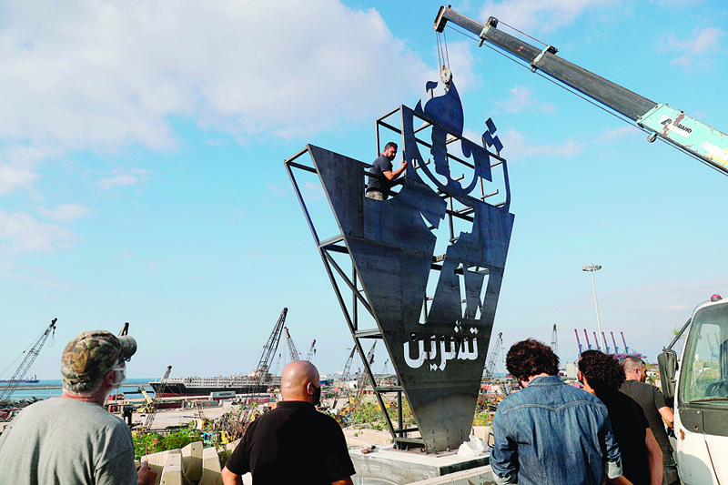 Lebanese activists erect a metalic monument on October 16, 2020, with 'October 17' written on it in Arabic, a day ahead of the one year anniversary of the beginning of a nationwide anti-government protest movement, in front of the devastated port of the capital Beirut where a massive explosion took place more than two months ago. (Photo by JOSEPH EID / AFP)