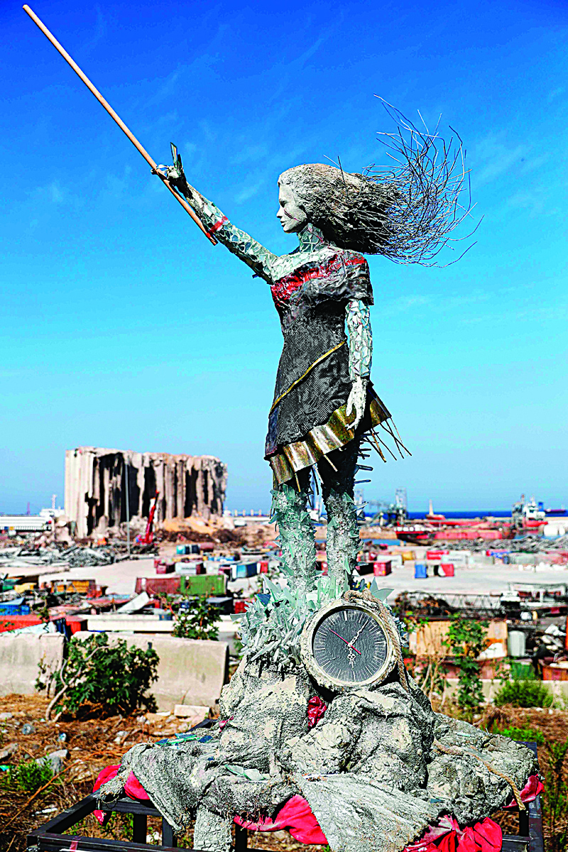 A statue of a woman made out of glass and rubble that resulted from the Beirut port mega explosion August 04, is placed opposite to the site of the blast in the Lebanese capital's harbour to mark the one year anniversary of the beginning of the anti-government protest movement across the country on October 20, 2020. - Hundreds marched in Beirut on the weekend to mark the first anniversary of a non-sectarian protest movement that has rocked the political elite but has yet to achieve its goal of sweeping reform. A whirlwind of hope and despair has gripped the country in the year since protests began, as an economic crisis and a devastating port explosion two months ago pushed Lebanon deeper into decay. (Photo by JOSEPH EID / AFP)