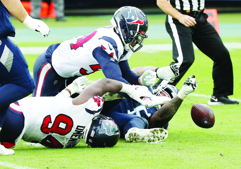NASHVILLE, TENNESSEE - OCTOBER 18: Jacob Martin #54 and Charles Omenihu #94 of the Houston Texans vie for the loose ball fumble in the third quarter against the Tennessee Titans at Nissan Stadium on October 18, 2020 in Nashville, Tennessee. Martin recovered the fumble. The Titans defeated the Texans 42-36.   Frederick Breedon/Getty Images/AFP