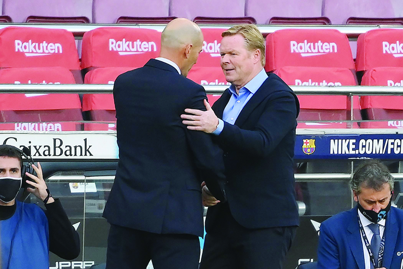 Barcelona's Dutch coach Ronald Koeman (R) congratulates Real Madrid's French coach Zinedine Zidane at the end of the Spanish League football match between Barcelona and Real Madrid at the Camp Nou stadium in Barcelona on October 24, 2020. (Photo by LLUIS GENE / AFP)