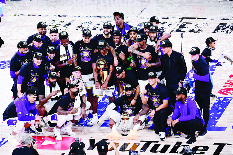 LAKE BUENA VISTA, FLORIDA - OCTOBER 11: The Los Angeles Lakers pose for a team photo with the trophy after winning the 2020 NBA Championship over the Miami Heat in Game Six of the 2020 NBA Finals at AdventHealth Arena at the ESPN Wide World Of Sports Complex on October 11, 2020 in Lake Buena Vista, Florida. NOTE TO USER: User expressly acknowledges and agrees that, by downloading and or using this photograph, User is consenting to the terms and conditions of the Getty Images License Agreement.   Douglas P. DeFelice/Getty Images/AFPn== FOR NEWSPAPERS, INTERNET, TELCOS &amp; TELEVISION USE ONLY ==