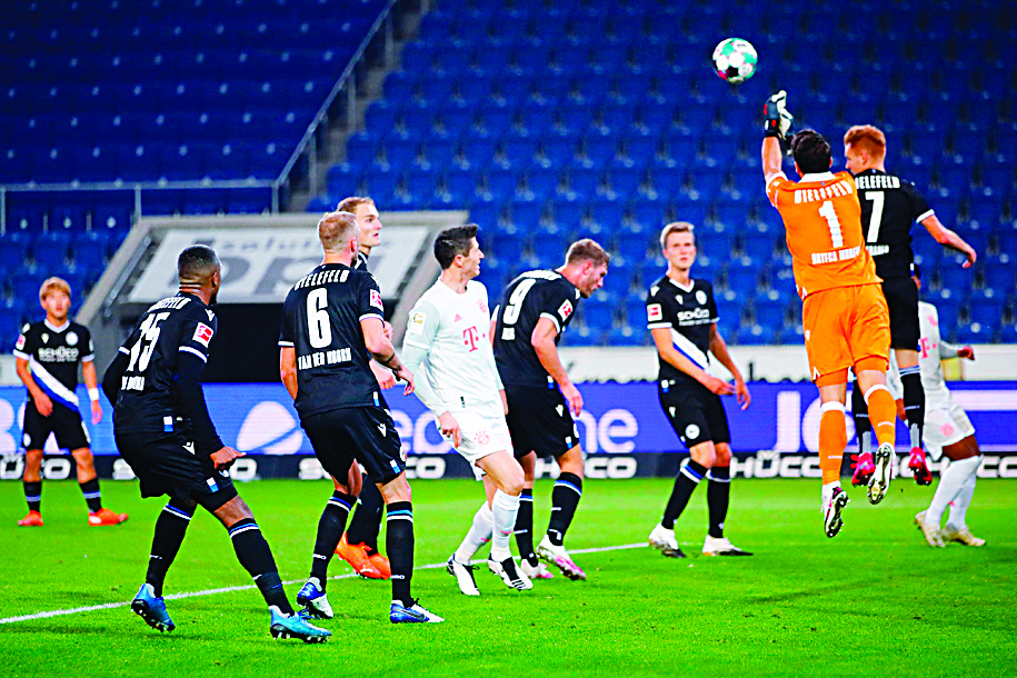 Arminia Bielefeld's goalkeeper Stefan Ortega (2R) jumps for the ball during the German first division Bundesliga football match between DSC Arminia Bielefeld and FC Bayern Munich at the SchuecoArena in Bielefeld, western Germany, on October 17, 2020. - Bayern Munich's Thomas Muller celebrates scoring their first goal with Serge Gnabry (Photo by WOLFGANG RATTAY / POOL / AFP) / DFL REGULATIONS PROHIBIT ANY USE OF PHOTOGRAPHS AS IMAGE SEQUENCES AND/OR QUASI-VIDEO