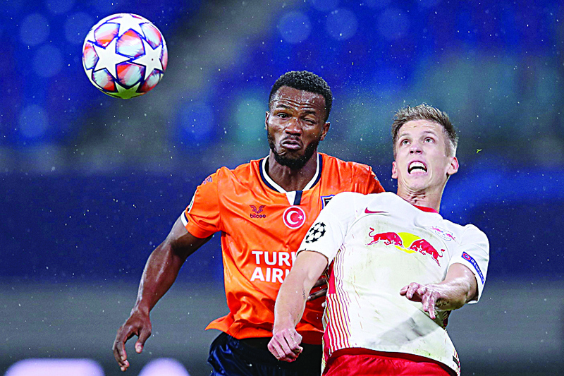 TOPSHOT - Istanbul Basaksehir's Belgian defender Boli Bolingoli Mbombo (L) and Leipzig's Spanish midfielder Dani Olmo both jump to head the ball during the UEFA Champions League Group H football match RB Leipzig v Istanbul Basaksehir FK in Leipzig, eastern Germany on October 20, 2020. (Photo by Ronny HARTMANN / AFP)