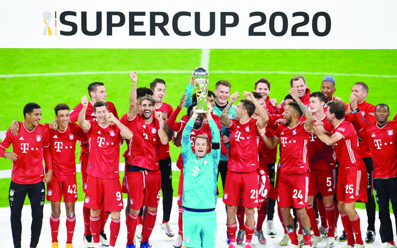 Bayern Munich's German goalkeeper Manuel Neuer and teammates celebrate with the trophy after winning the German Supercup football match FC Bayern Munich v BVB Borussia Dortmund in Munich, Southern Germany, on September 30, 2020. (Photo by ANDREAS GEBERT / POOL / AFP) / DFL REGULATIONS PROHIBIT ANY USE OF PHOTOGRAPHS AS IMAGE SEQUENCES AND/OR QUASI-VIDEO