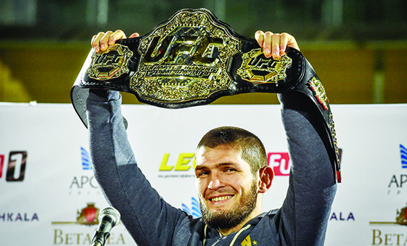 (FILES) In this file photo taken on October 8, 2018 UFC lightweight champion Khabib Nurmagomedov of Russia raises his champions belt upon the arrival in Makhachkala. - World lightweight mixed martial arts (MMA) champion Khabib Nurmagomedov, unbeaten in 29 fights, has announced on October 24, 2020 to everyone's surprise that he retires at 32 to keep a promise made to his mother. (Photo by Vasily MAXIMOV / AFP)