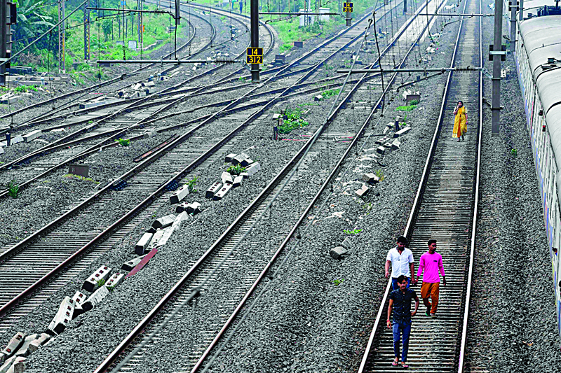 Passengers walk on a railway track after trains got stranded due to a major power cut in several areas after grid failure in Mumbai on October 12, 2020. (Photo by INDRANIL MUKHERJEE / AFP)