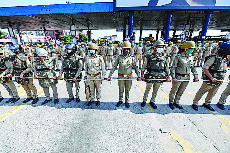 Police stand guard as National Congress leader Rahul Gandhi is allowed to move with his sister Priyanka Gandhi Vadra and other party leaders towards the Uttar Pradesh state to meet the relatives of the 19-year-old allegedly gang-raped victim, at the Delhi Noida Direct flyway toll plaza on October 3, 2020. - Five senior police officers have been suspended over their handling of an investigation into the gang-rape and murder of a 19-year-old woman that has sparked outrage across India and triggered days of protests. (Photo by Sajjad HUSSAIN / AFP)