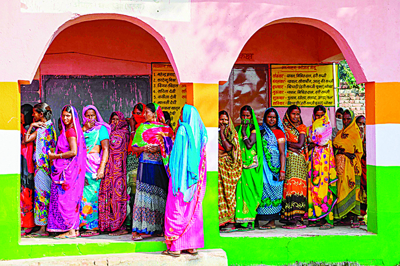 TOPSHOT - Voters queue up to cast their ballots for Bihar state assembly elections at a polling station in Masaurhi on October 28, 2020. (Photo by Prakash SINGH / AFP)