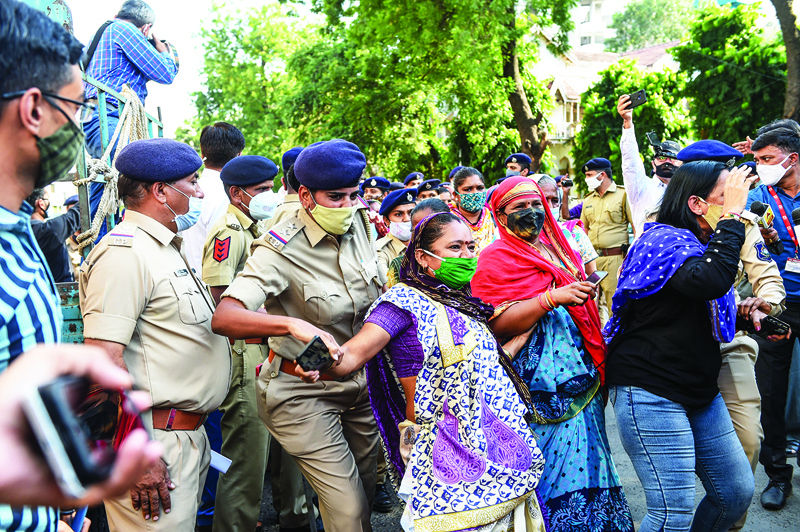 Police personnel (L) detain Congress party supporters participating in a protest rally against the alleged gang-rape and murder of a low-caste teenaged woman at Bool Garhi village of Uttar Pradesh state, in Ahmedabad on October 7, 2020. (Photo by SAM PANTHAKY / AFP)