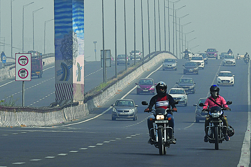 Commuters drive along a road under smog conditions in New Delhi on October 22, 2020. (Photo by Prakash SINGH / AFP)