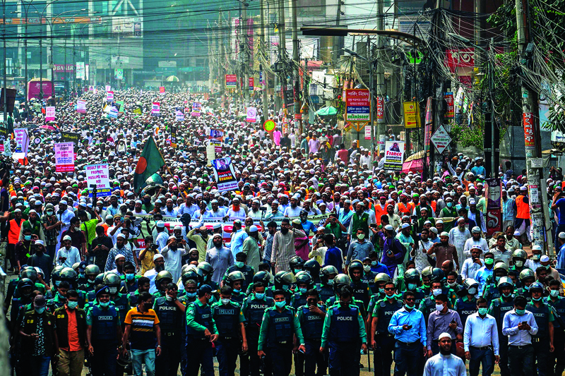 TOPSHOT - Activists and supporters of the Islami Andolon Bangladesh, a Islamist political party, hold a protest march calling for the boycott of French products and denouncing French president Emmanuel Macron for his comments over Prophet Mohammed caricatures, in Dhaka on October 27, 2020. (Photo by Munir UZ ZAMAN / AFP)