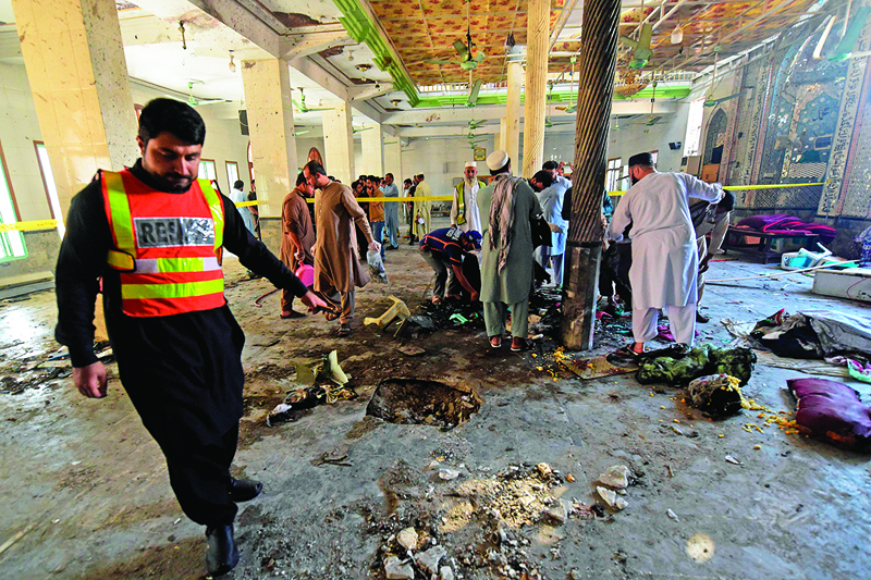 TOPSHOT - Rescue workers collect remains at the site of a blast in a religious school in Peshawar on October 27, 2020. - At least four students were killed and dozens more wounded on October 27 when a bomb exploded during a class at their religious school in Pakistan, officials said. (Photo by Abdul MAJEED / AFP)