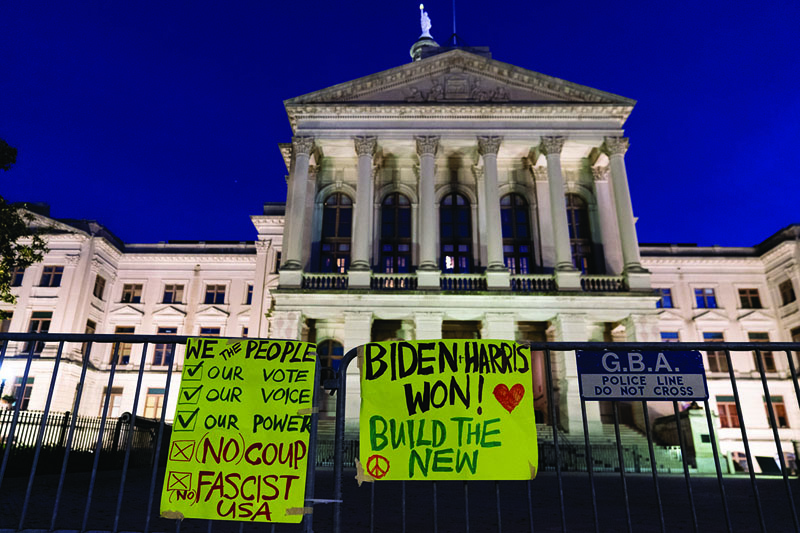 ATLANTA, GA - NOVEMBER 14: Signs supporting President-elect Joe Biden are seen on a fence outside the Georgia State Capitol on November 14, 2020 in Atlanta, Georgia. President-elect Joe Biden has been declared the winner in Georgia, becoming the first Democratic nominee to win the state since 1992.   Elijah Nouvelage/Getty Images/AFP