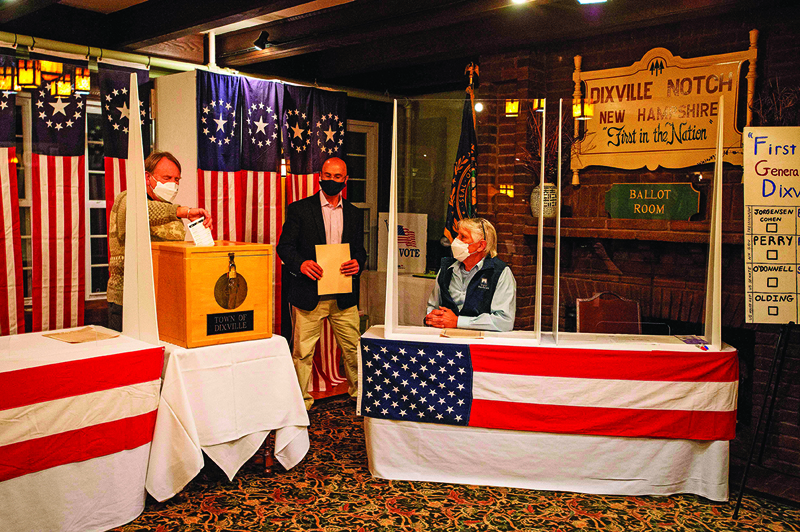Tom Tillotson drops voters ballots into the ballot box at the Hale House at the historic Balsams Resort during midnight voting as part of the first ballots cast in the United States Presidential Election in Dixville Notch, New Hampshire on November 3, 2020. - Voters in Dixville Notch, a village of 12 residents in the US state of New Hampshire, kicked off Election Day at the stroke of midnight on Tuesday by voting unanimously for Democratic nominee Joe Biden. (Photo by Joseph Prezioso / AFP)