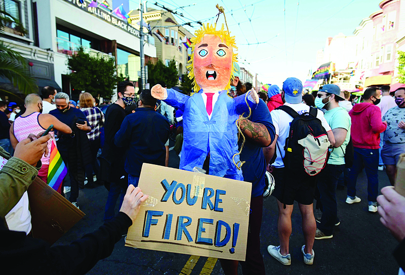 TOPSHOT - People hold a pinata of US President Donald Trump as people celebrate Joe Biden being elected President of the United States in the Castro district of San Francisco, California on November 7, 2020. - Democrat Joe Biden has won the White House, US media said November 7, defeating Donald Trump and ending a presidency that convulsed American politics, shocked the world and left the United States more divided than at any time in decades. (Photo by JOSH EDELSON / AFP)