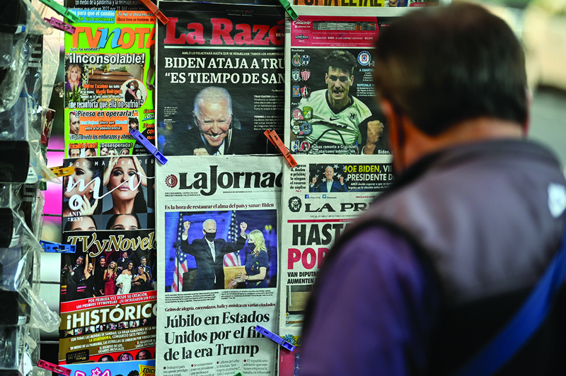 This picture taken on November 8, 2020 in Mexico City shows a collection of Mexican newspaper front pages, headlines featuring the 2020 US general election results. (Photo by Pedro PARDO / AFP)