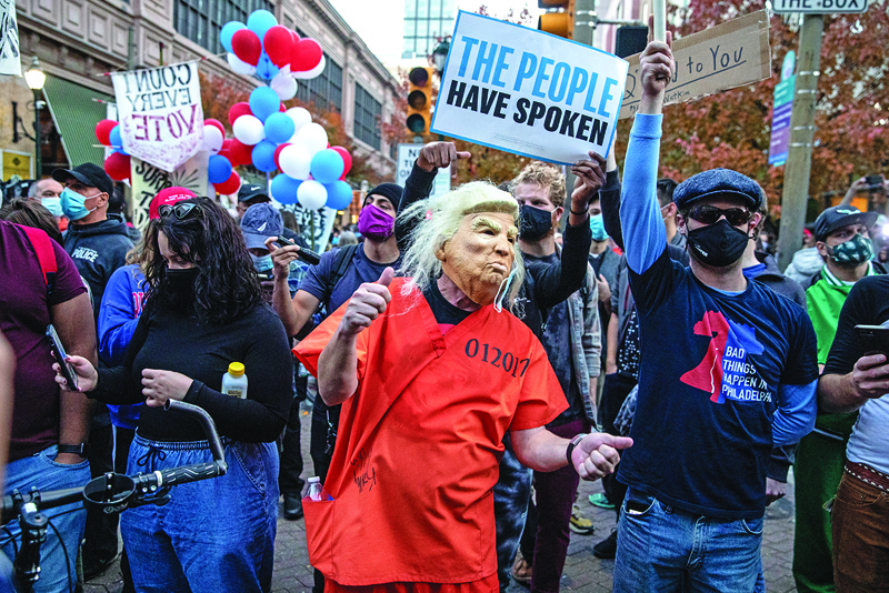 PHILADELPHIA, PENNSYLVANIA - NOVEMBER 06: A person dressed as Donald Trump in a prison jumpsuit dances in front of supporters of U.S. President Donald Trump outside of the Philadelphia Convention Center as the counting of ballots continues in the state on November 06, 2020 in Philadelphia, Pennsylvania. Joe Biden took the lead in the vote count in Pennsylvania on Friday morning from President Trump, as mail-in ballots continue to be counted in the battleground state.   Chris McGrath/Getty Images/AFP