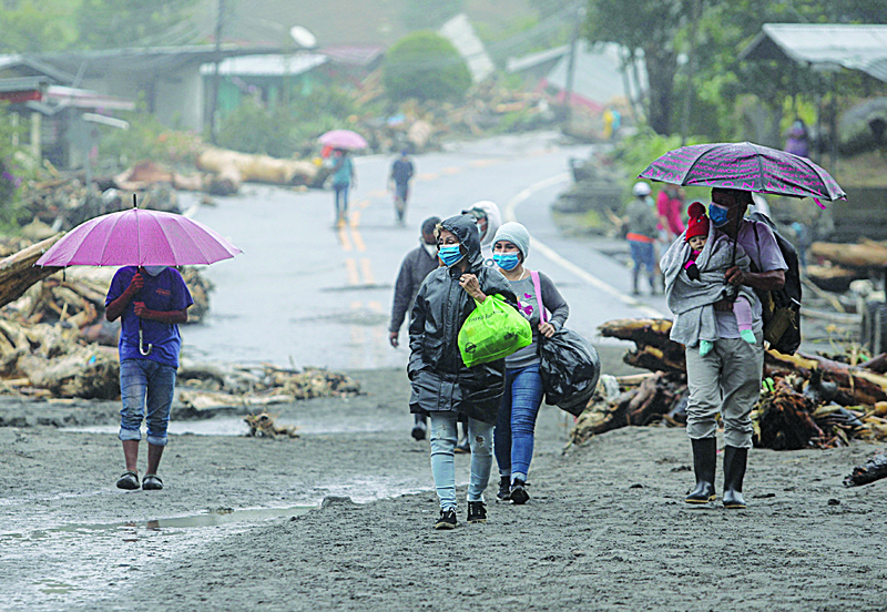 People evacuate after the overflow of Bambito river due to heavy rains caused by Hurricane Eta, now degraded to a tropical storm, in Bambito, Chiriqui Province, on November 6, 2020. - Panama was the latest country to feel Eta's wrath, as landslides buried two homes in Chiriqui province on the Costa Rican border, killing five people, the National Protection System said. Among the victims were three children. (Photo by MAURICIO VALENZUELA / AFP)