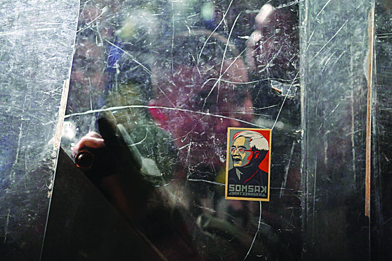A sticker of self-exiled Thai academic Somsak Jeamteerasakul is stuck on a police riot shield next to the Thai Parliament as pro-democracy protesters hold a rally in Bangkok on November 17, 2020. (Photo by Mladen ANTONOV / AFP)