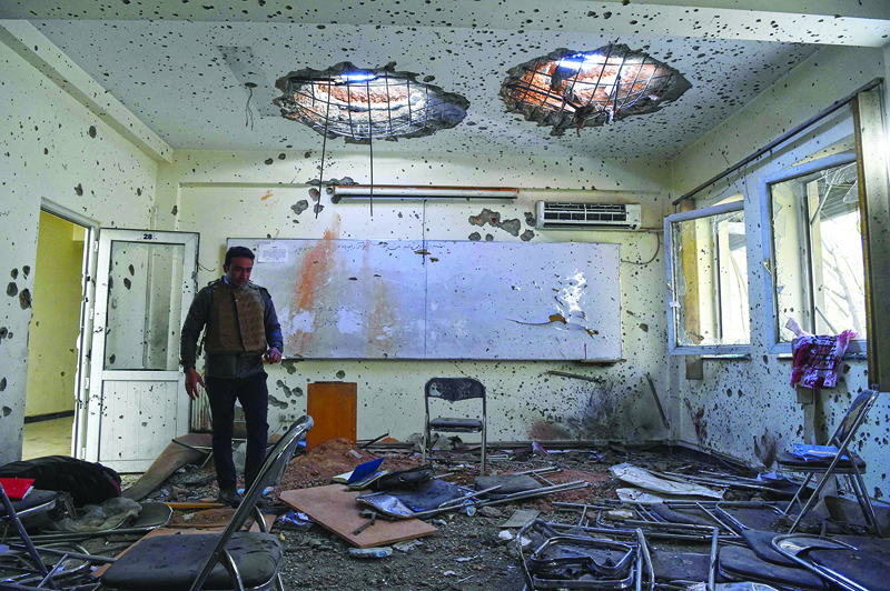 TOPSHOT - A journalist walks inside of a damaged class of the National Legal Training center, a day after gunmen stormed Kabul university in Kabul on November 3, 2020. - Stunned students demonstrated outside Kabul University on November 3 after at least 22 people were killed in a brutal, on-campus attack claimed by the Islamic State group. (Photo by WAKIL KOHSAR / AFP)