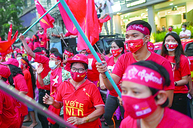Supporters of the National League for Democracy (NLD) party react in front of the party's headquarters in Yangon on November 9, 2020, as NLD officials said they were confident of a landslide victory in the weekend's election. (Photo by Ye Aung Thu / AFP)