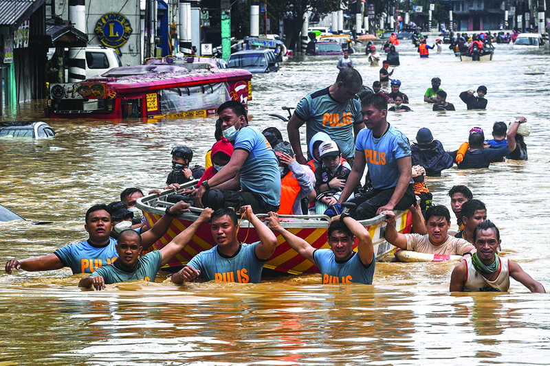 TOPSHOT - Rescuers pull a rubber boat carrying residents through a flooded street after Typhoon Vamco hit in Marikina City, suburban Manila on November 12, 2020. (Photo by Ted ALJIBE / AFP)