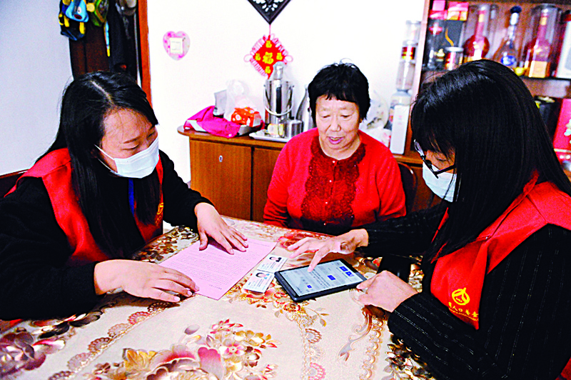 Census workers use an app to collect information from a resident in Qingdao, in China's eastern Shandong province on November 1, 2020, as millions of census-takers began knocking on doors for a once-a-decade head count of the world's largest population that for the first time will use mobile apps to help crunch the massive numbers. (Photo by STR / AFP) / China OUT