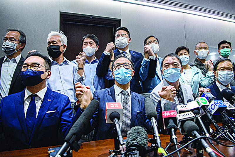 Pro-democracy lawmakers join hands at the start of a press conference in a Legislative Council office in Hong Kong on November 11, 2020. - Hong Kong's pro-democracy lawmakers said on November 11 they would all resign, after China gave the city the power to disqualify politicians deemed a threat to national security and four of their colleagues were ousted. (Photo by Anthony WALLACE / AFP)