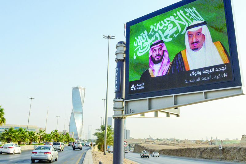 A picture taken on November 18, 2020 shows an electronic billboard bearing the portraits of Saudi King Salman bin Abdulaziz (R) and his son Crown Prince Mohammed bin Salman ahead of a meeting of Finance ministers and central bank governors of the G20 nations in the Saudi capital Riyadh. - Saudi Arabia hosts the G20 summit Saturday in a first for an Arab nation, but the scaled-down virtual format could limit debate on a resurgent coronavirus pandemic and crippling economic crisis. (Photo by FAYEZ NURELDINE / AFP)