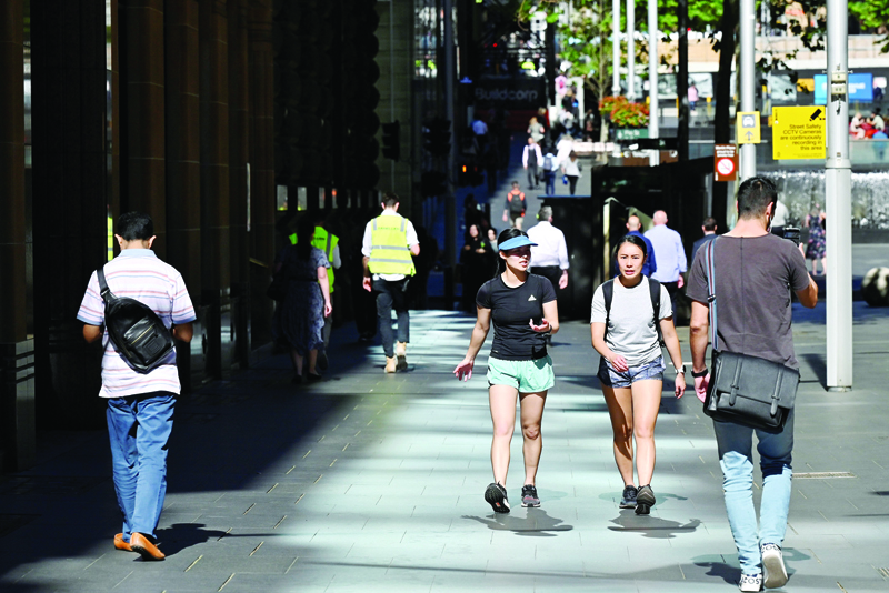 People walk in the central business district of Sydney on November 3, 2020. (Photo by Saeed KHAN / AFP)