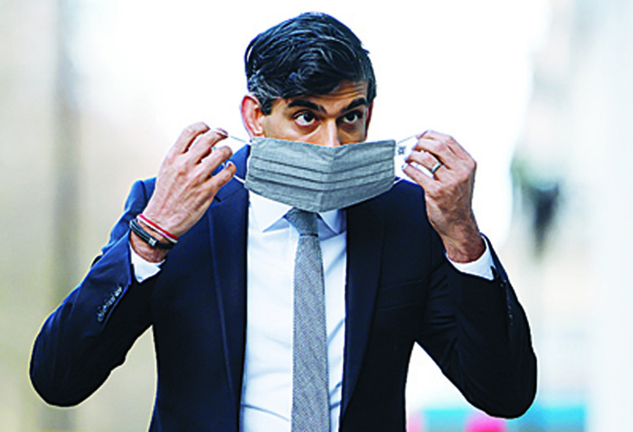 Britain's Chancellor of the Exchequer Rishi Sunak puts on a face covering due to the COVID-19 pandemic, as enters the BBC in central London on November 22, 2020, to take appear on the BBC political programme The Andrew Marr Show. - Britain's debt is now at its highest level since 1961 as a share of GDP, after the government embarked on a massive spending spree to mitigate the economic effects of the COVID-19 coronavirus pandemic and resulting lockdowns. (Photo by Tolga Akmen / AFP)