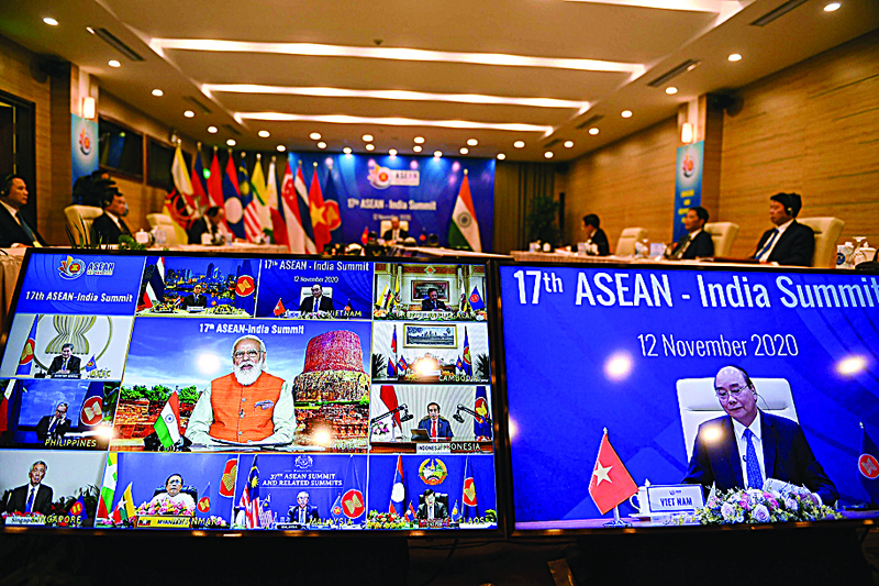 Indian Prime Minister Narendra Modi (C on left screen) addresses counterparts with Vietnam's Prime Minister Nguyen Xuan Phuc (R screen) at the ASEAN-India Summit of the Association of Southeast Asian Nations (ASEAN), on a live video conference held online due to the COVID-19 coronavirus pandemic, in Hanoi on November 12, 2020. (Photo by Nhac NGUYEN / AFP)