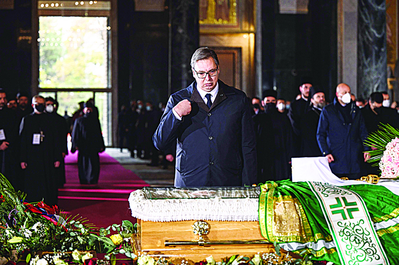 Serbian President Aleksandar Vucic pays his last respect next to the casket of late Serbian patriarch Irinej during a funeral service at Belgrade's Saint Sava temple, on November 22, 2020. - Patriarch Irinej, the head of the Serbian Orthodox Church, died of coronavirus on November 20, 2020, three weeks after his unofficial second-in-command also succumbed to Covid-19, the church said. (Photo by Andrej ISAKOVIC / AFP)