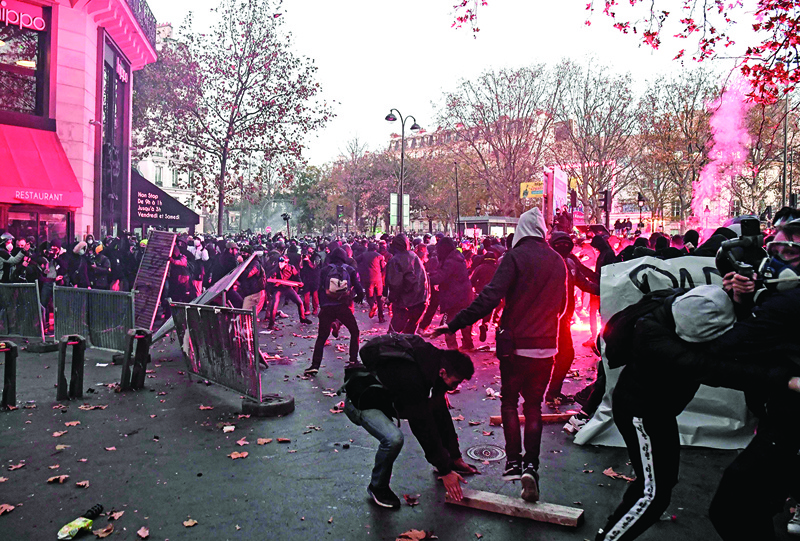 Demonstrators clashes with French riot police during a protest against the 'global security' draft law, which Article 24 would criminalise the publication of images of on-duty police officers with the intent of harming their 'physical or psychological integrity', in Paris, on November 28, 2020. - Dozens of rallies are planned on November 28 against a new French law that would restrict sharing images of police, only days after the country was shaken by footage showing officers beating and racially abusing a black man. (Photo by ALAIN JOCARD / AFP)