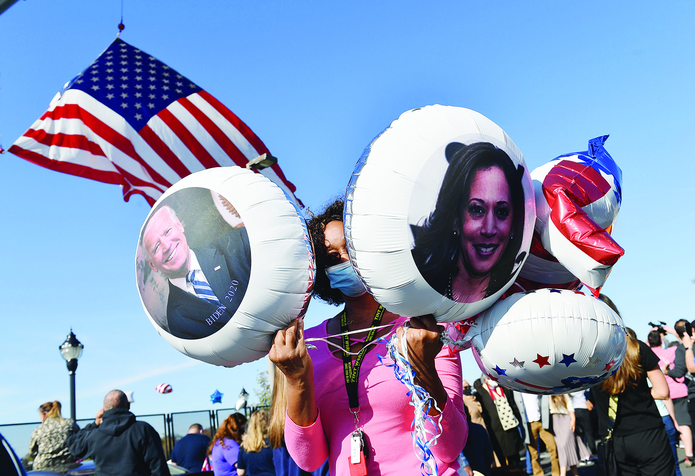 WILMINGTON, Delaware: A supporter holds balloons with the images of US President-elect Joe Biden and Vice President-elect Kamala Harris as people celebrate Biden’s victory in the 2020 presidential election outside the Chase Center yesterday. — AFP