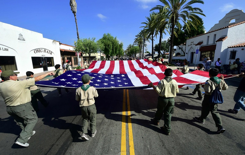 (FILES) In this file photo taken on July 04, 2018 the national flag is carried by Boy Scouts during a parade in San Gabriel, California as cities and towns across America celebrate Independence Day. - More than 80,000 victims of sexual abuse that took place in the Boy Scouts of America (BSA) are expected to come forward by Monday evening, the deadline to receive compensation from the organization, a lawyer for the victims told AFP. (Photo by Frederic J. BROWN / AFP)