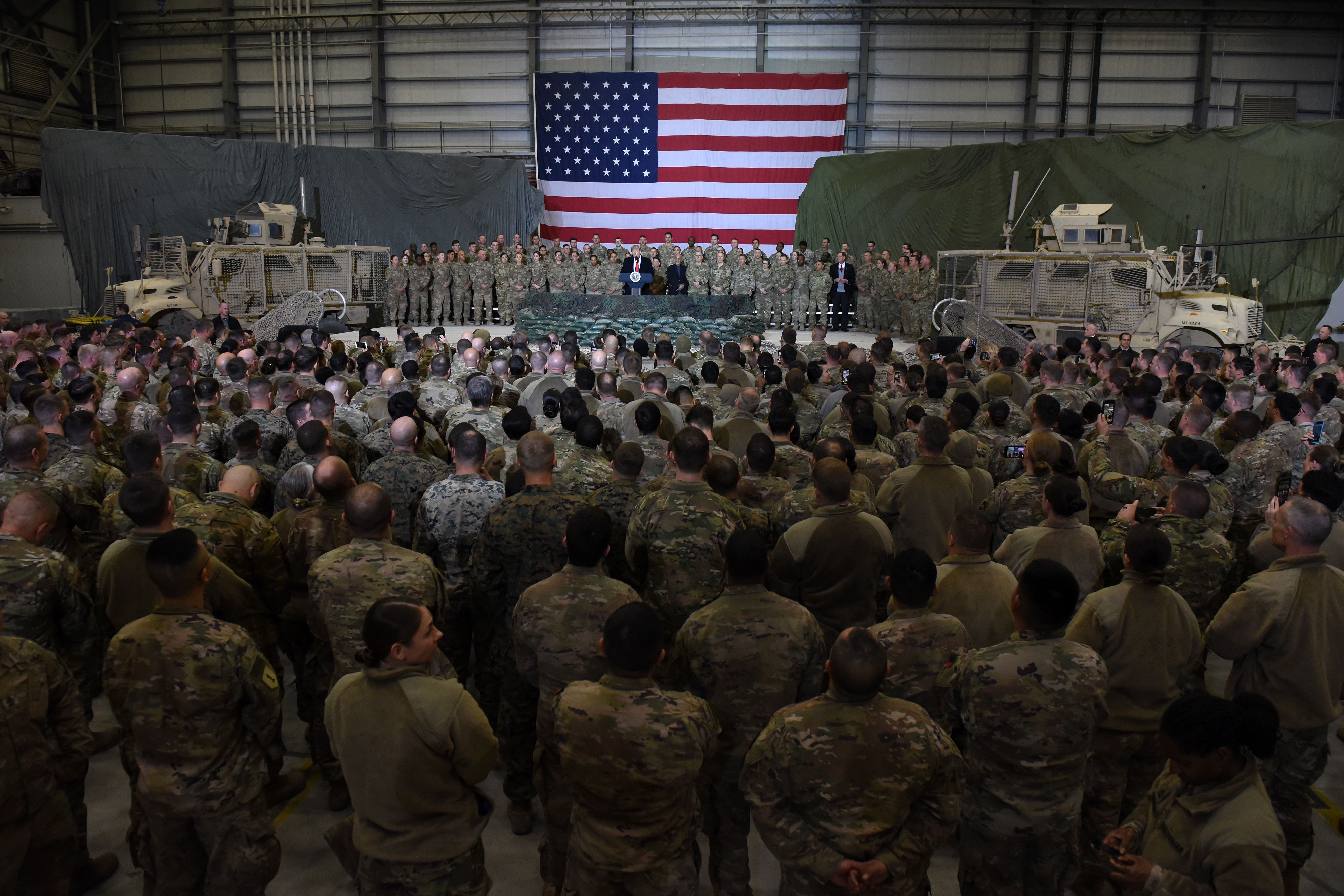 (FILES) In this file photo US President Donald Trump speaks to the troops during a surprise Thanksgiving day visit at Bagram Air Field, on November 28, 2019 in Afghanistan. - The US will cut its troops in Afghanistan to 2,500 in January, the lowest level in nearly two decades of war, as outgoing President Donald Trump follows through on a pledge to end conflicts abroad, the Pentagon announced on November 17, 2020. Acting Defense Secretary Chris Miller said around 2,000 troops would be pulled from the country by January 15, and 500 more would come back from Iraq, leaving 2,500 in each country. (Photo by Olivier Douliery / AFP)
