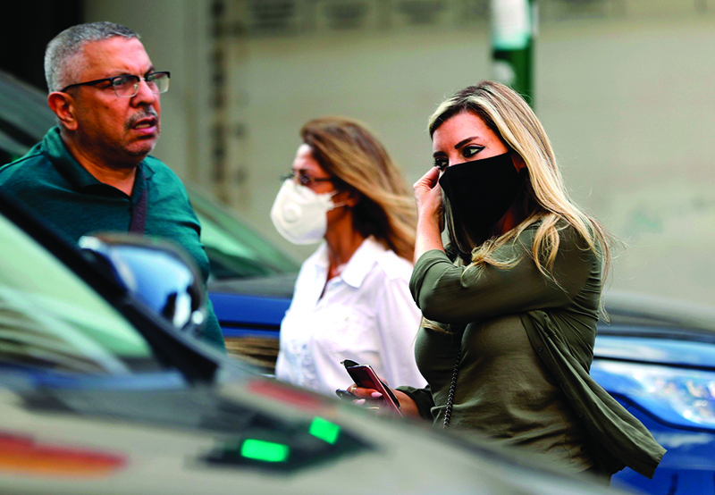 A woman adjusts her mask (COVID-19 coronavirus pandemic) as she walks along a street in Lebanon's capital Beirut on November 2, 2020. (Photo by JOSEPH EID / AFP)