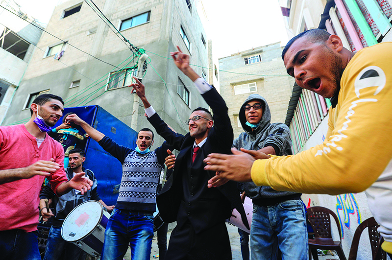 GAZA: Palestinian groom Mohammed Ahmed Ashour (center) dances with male relatives and friends while waiting for his bride during his wedding ceremony on Nov 12, 2020. — AFP
