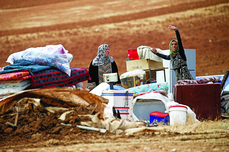 TOPSHOT - Palestinian bedouins stand next to their belongings after Israeli soldiers demolished their tents in an area east of the village of Tubas, in the occupied West Bank, on November 3, 2020. (Photo by JAAFAR ASHTIYEH / AFP)