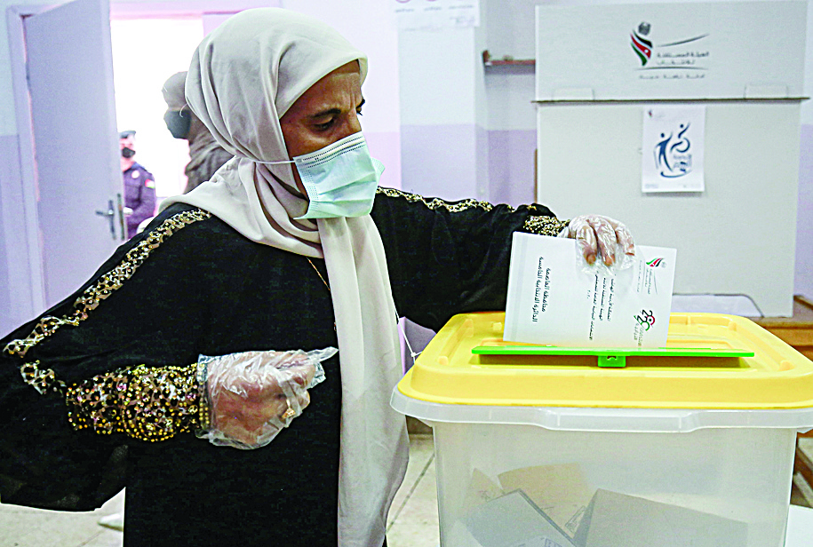 A voter, mask-clad due to the COVID-19 coronavirus pandemic, casts her ballot at a polling station in Jordan's capital Amman on November 10, 2020, during the 2020 general election. - Voters in coronavirus-battered Jordan go to the polls on November 10 in an election focused on the Arab country's economic crisis which has been heightened by the devastating pandemic. Although there have been some calls on social media to postpone the elections, the government has said the vote will go ahead. Parliament was already dissolved in late September ahead of the vote, and under the law new elections must be held within four months. (Photo by Khalil MAZRAAWI / AFP)