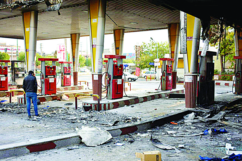 (FILES) In this file photo taken on November 17, 2019 an Iranian man checks a scorched gas station that was set ablaze by protesters during a demonstration against a rise in gasoline prices in Eslamshahr, near the Iranian capital of Tehran. - One year after protests harshly suppressed by the Iranian authorities, grief over the hundreds of mainly young lives lost is matched by anger over the lack of accountability over a crackdown whose scale is only beginning to emerge. (Photo by - / AFP)